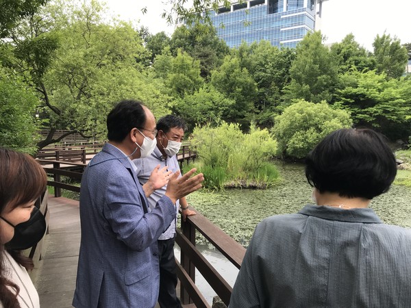 박완희 의원이 생태공원 관계자들에게 두꺼비생태공원의 물순환 체계를 설명하고 있다. 